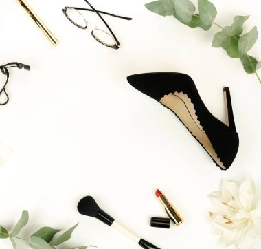 Düz yatıyordu, üstten görünüm kadın siyah yüksek topuklu ayakkabı, aksesuar ve kozmetik beyaz bir arka plan üzerinde oluşturuyor. çanta, başörtüsü, Gözlük, ruj, maskara, toz, fırça, parfüm içerir. Kopya alanı.