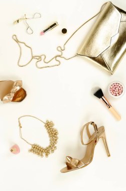 Kadın yüksek topuklu ayakkabı sandalet altın renk, aksesuar debriyaj çanta, kolye ve beyaz bir arka plan üzerinde kozmetik makyaj düz yatıyordu, en iyi görünüm. Glamour arka plan. Kopya alanı .