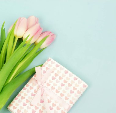 Sevgililer günü arka plan en az kavramı. Buket pembe laleler ve soluk bleu arka plan üzerinde hediye. Üstten görünüm. Kopya alanı