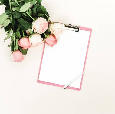 gül ve ışık zemin üzerinde düzenlenmiş boş not defteri üstten görünüm