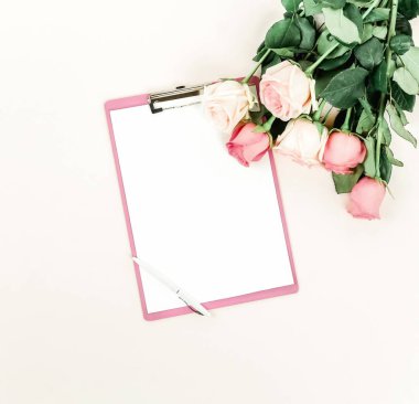 gül ve ışık zemin üzerinde düzenlenmiş boş not defteri üstten görünüm