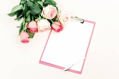 gül ve ışık zemin üzerinde düzenlenmiş boş not defteri üstten görünüm