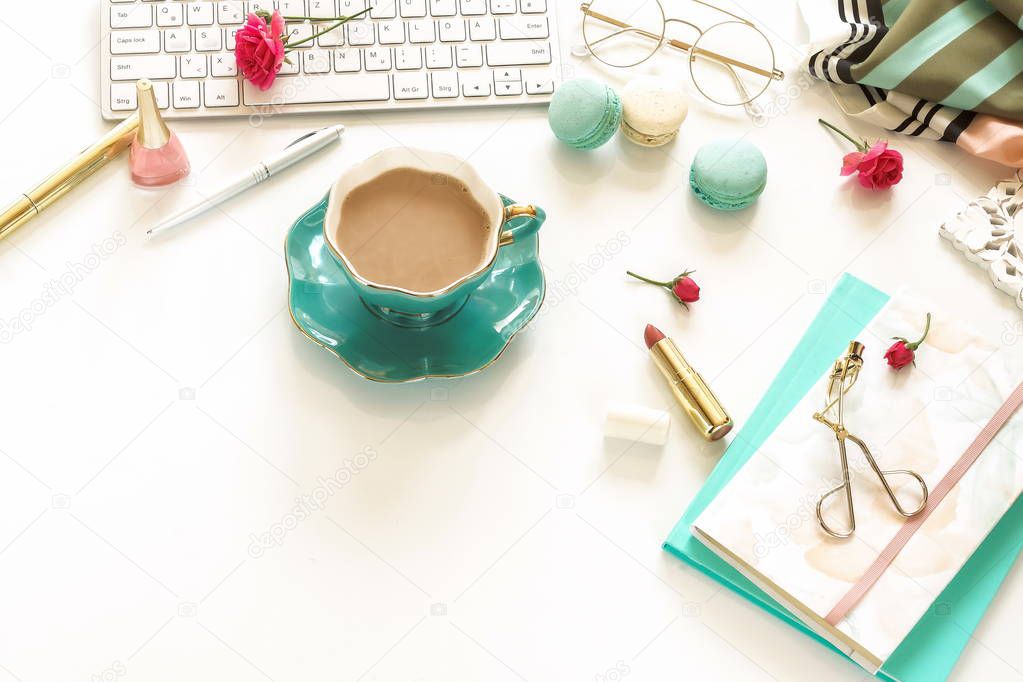 female workspace with keyboard, notebooks, cup of cocoa on white background