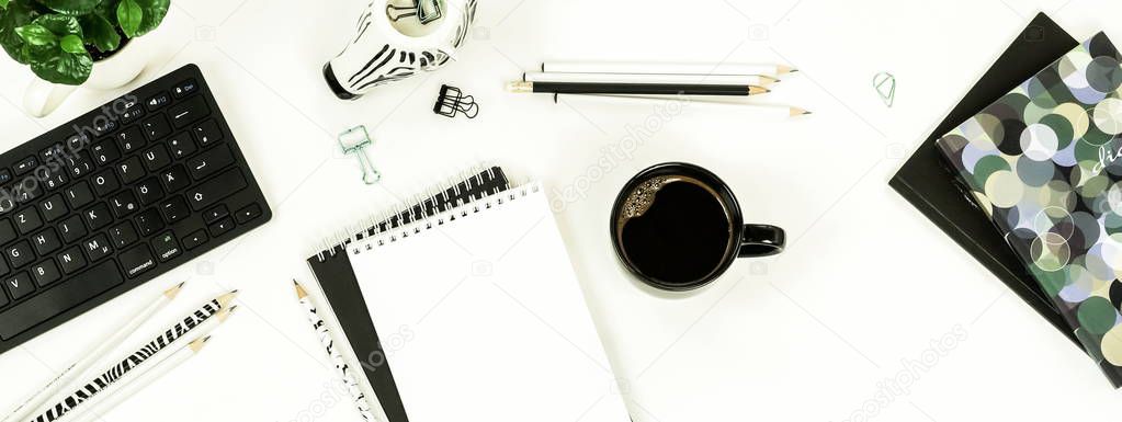 female workspace with keyboard, notebooks, cup of coffee on white background