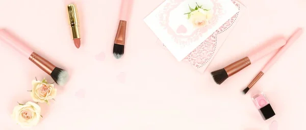 バラとピンク背景に配置された女性的な化粧機器のトップ ビュー — ストック写真