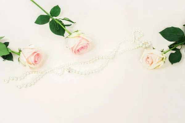 Top View Beautiful Roses Pearl Necklace Beige Backdrop — Stock Photo, Image