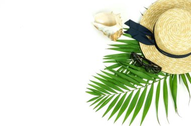 Beyaz arka plan üzerinde yukarıdan hasır şapka, güneş gözlüğü ve palmiye yaprakları