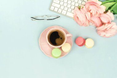 klavye, gözlük, tipik çiçekler, macarons ve kahve kadın çalışma alanı