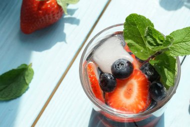 ahşap zemin üzerinde taze çilek ile su cam