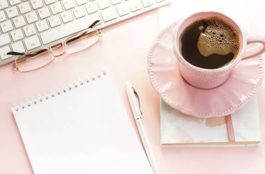 pembe arka plan üzerinde klavye ve kahve fincan ile kadın çalışma alanı 