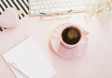 pembe arka plan üzerinde klavye ve kahve fincan ile kadın çalışma alanı 
