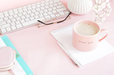 pembe arka plan üzerinde klavye ve kahve fincan ile kadın çalışma alanı 