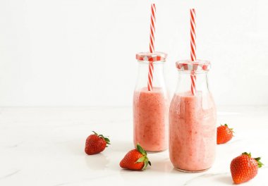 Çilek smoothie veya milkshake mermer arka plan üzerinde bir bardak. Kahvaltı ve atıştırmalık için sağlıklı yiyecekler. kopyalama alanı