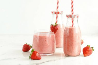 Çilek smoothie veya milkshake mermer arka plan üzerinde bir bardak. Kahvaltı ve atıştırmalık için sağlıklı yiyecekler. kopyalama alanı