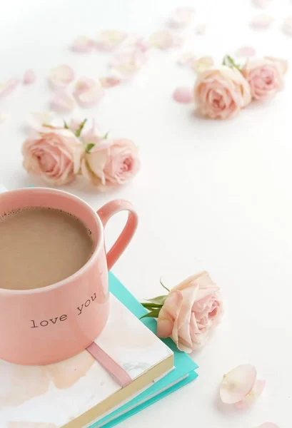 白い背景に美しいピンクの花 ノート コーヒーのカップのクローズアップビュー — ストック写真