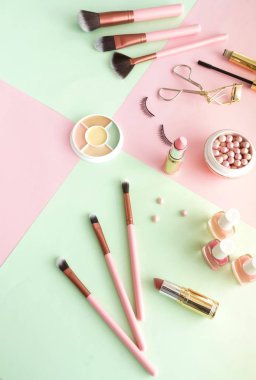 pembe ve yeşil arka plan üzerinde kadın güzellik ekipmanları
