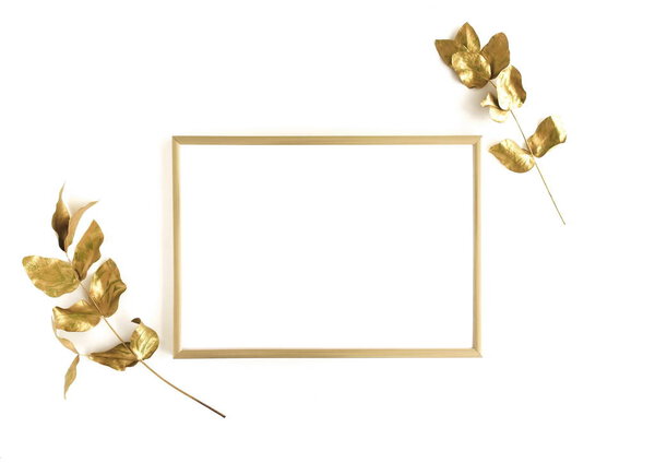 Golden eucalyptus leaves and golden frame mock up om white background isolated top view, flat lay, copy space. Greetings floral minimal card