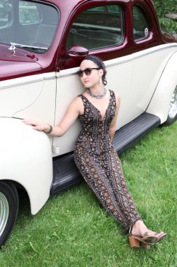 Güzel esmer kadın modeli ile birlikte eski model bir araba