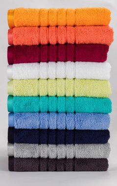 Beyaz zemin üzerinde çok renkli havlular yığını