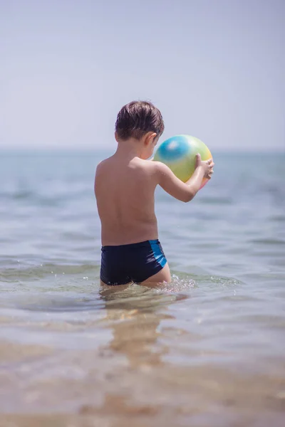 Schattige Jongen Permanent Het Water Het Strand Een Kleurrijke Strandbal — Stockfoto