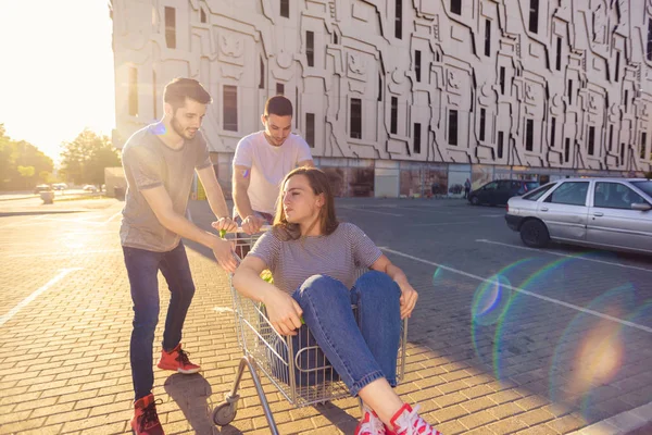 Teenage Mädchen Shopping Trolley Having Fun Während Two Guys Push — Stockfoto