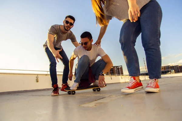 Aktywny Nastolatek Ujeżdżający Longboard Przyjaciółmi Dachu Budynku — Zdjęcie stockowe