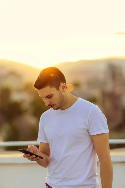 Teenager Stojí Balkóně Sunset Textových Zpráv Svůj Mobilní Telefon — Stock fotografie