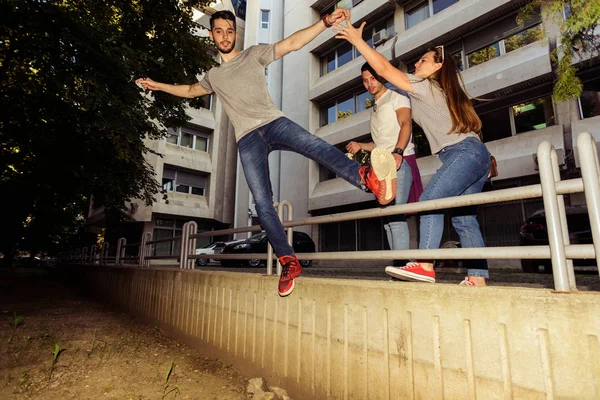 Drei Freunde Haben Spaß Während Einer Von Der Wand Springt — Stockfoto