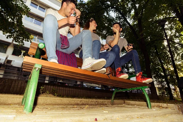 Drei Freunde Unterhalten Sich Bei Sonnigem Wetter Auf Einer Holzbank — Stockfoto