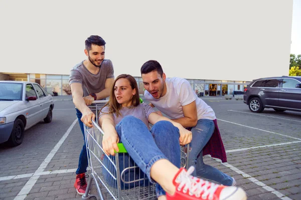 Dos Amigos Conduciendo Chica Con Carrito Compras Estacionamiento —  Fotos de Stock