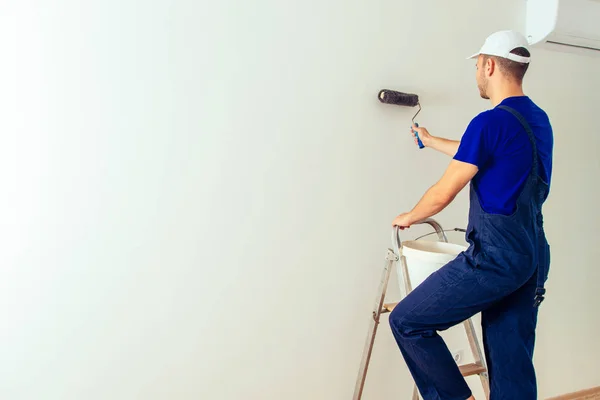 Vista Trasera Del Hombre Pintor Mirando Pared Blanca Con Rodillo —  Fotos de Stock