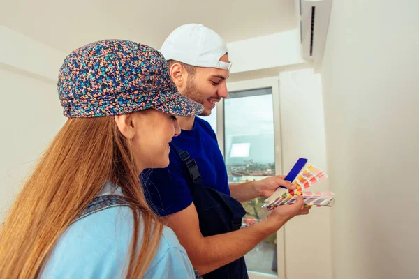 Junges Paar Overall Mit Farbführer Und Pinsel Auf Weißem Hintergrund — Stockfoto