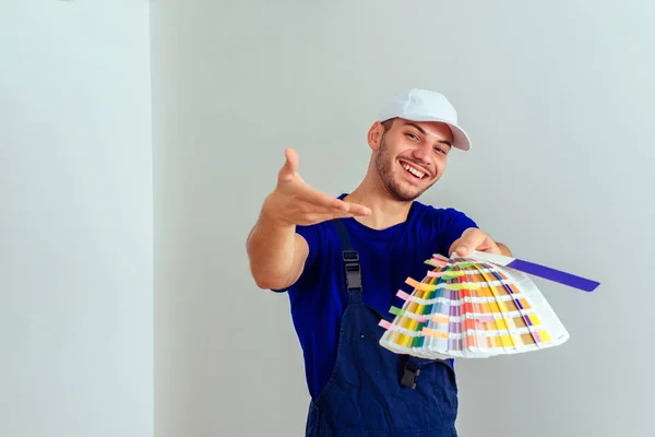 均一な色を選んでいる間白い背景の帽子立っている男 — ストック写真