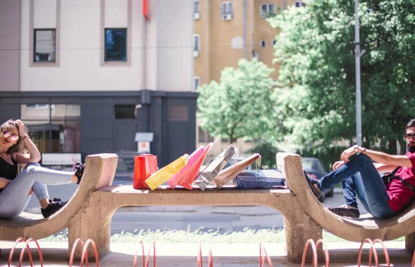 Genç Çift Alışveriş Sonra Dinlenmek Için Bir Beton Bankta Oturuyor — Stok fotoğraf