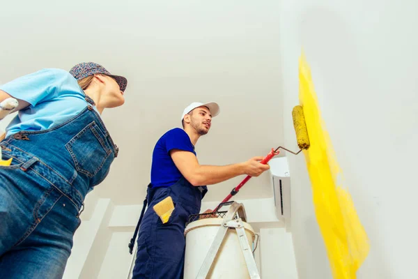 Joven Pareja Casada Enjoyng Mientras Pintan Habitación Amarillo — Foto de Stock