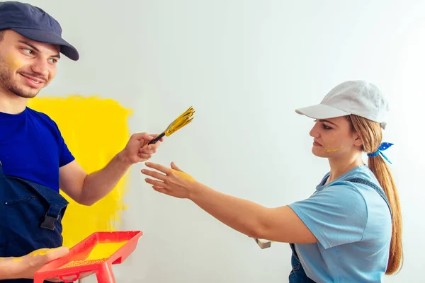 Couple Uniform Holding Together Paintbrush Yellow Color While Painting Walls — Stock Photo, Image