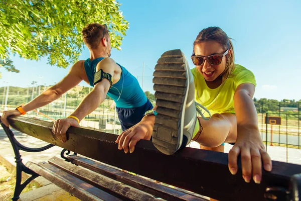 屋外で公園のベンチに足を伸ばしランナー選手 — ストック写真