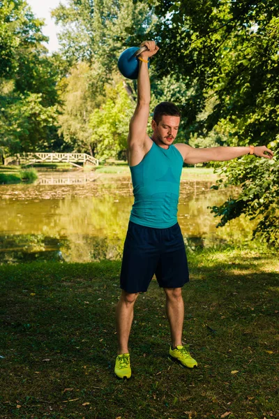 自然に重いケトルベルを持ち上げて ウエイト トレーニングを行うフィットネス男 — ストック写真