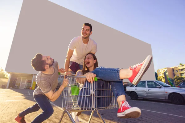 Dos Tipos Conduciendo Carrito Compras Con Una Chica Estacionamiento —  Fotos de Stock