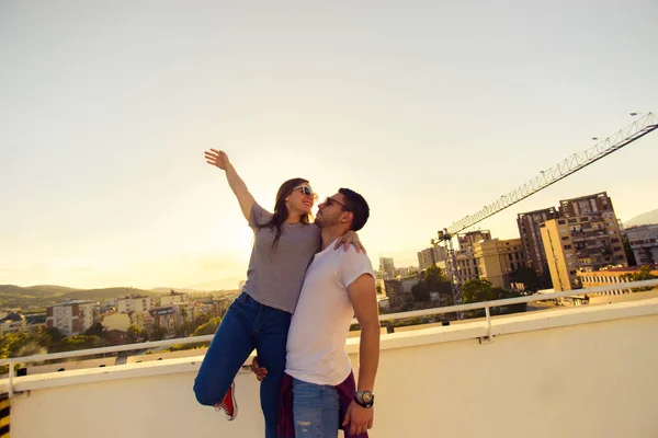 Sweet young couple hugging on a balcony in the sunlight