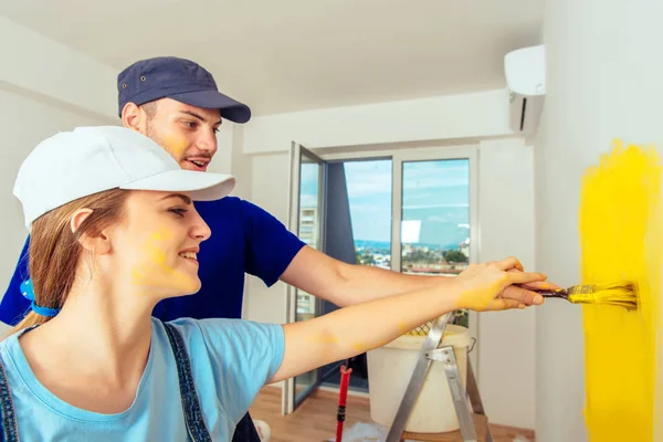 Girl Painting Wall Yellow Paint While Her Boyfriend Holding Her — Stock Photo, Image