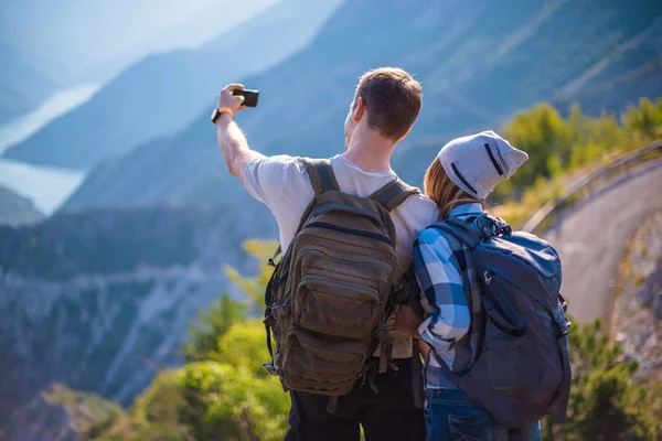 新鮮な山の空気を呼吸します 若いカップルは 夏に山でハイキングしながら Selfie を作るします 夏の山でハイキング コンセプト — ストック写真