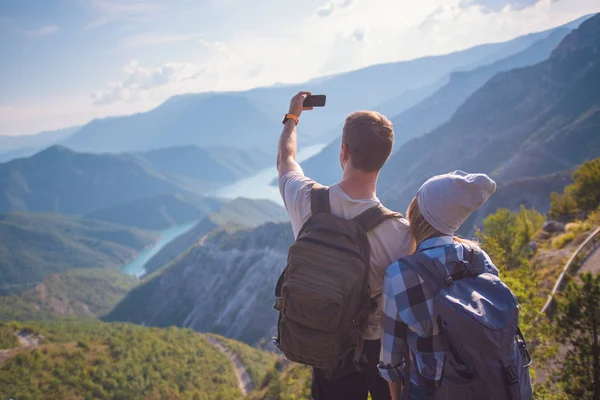 新鮮な山の空気を呼吸します 若いカップルは 夏に山でハイキングしながら Selfie を作るします 夏の山でハイキング コンセプト — ストック写真