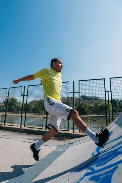 남자는 시내에서 장애물을 뛰어넘는 파리를 시킨다 — 스톡 사진