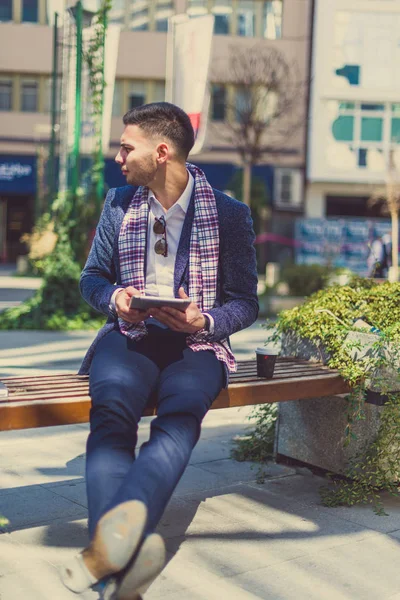 Ein Mann Sitzt Mit Gekreuzten Beinen Auf Der Bank Der — Stockfoto