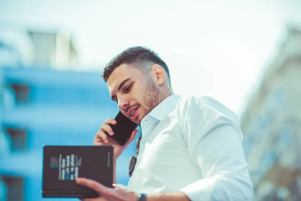 Hombre Negocios Con Camisa Blanca Hablando Teléfono Inteligente Mientras Sostiene —  Fotos de Stock