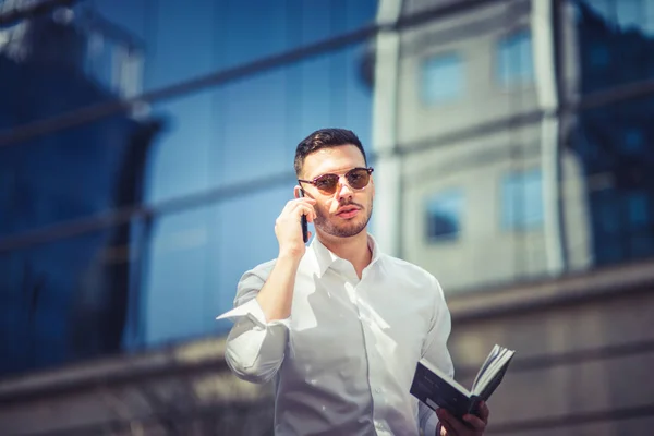 Der Städtische Geschäftsmann Telefoniert Während Mit Brille Sonnenbrille Und Notizbuch — Stockfoto