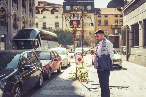 Młody Przystojny Człowiek Stoi Miejskich Miasta Patrząc Dół Trzymając Jego — Zdjęcie stockowe