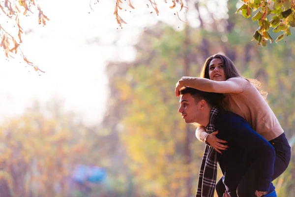 美しいガール フレンドは彼を驚かせようと彼女の彼氏の背中にジャンプします — ストック写真