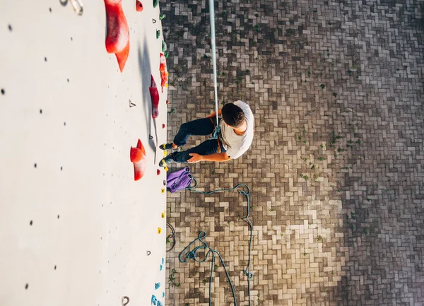 クライミングセンターの実用的な岩の上に降りて若い登山家 ボルダリング — ストック写真